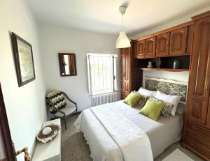 a bedroom with a white bed with green pillows at Casa Pancha in Ribadeo