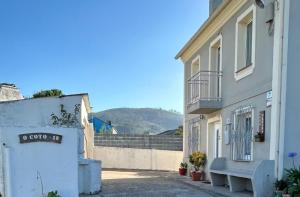 a building with a bench on the side of a street at Casa Pancha in Ribadeo