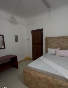 桑给巴尔Spice Garden Lodge B&B的带床和木门的卧室 更多2张照片