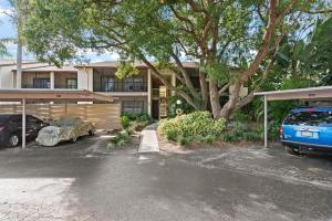 a house with a car parked in a parking lot at Tranquil condo minutes from Venice Beach - Beach Bungalow in Nokomis