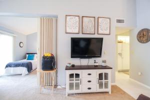 a living room with a flat screen tv on a wall at Tranquil condo minutes from Venice Beach - Beach Bungalow in Nokomis