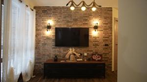 un salon avec une télévision sur un mur en briques dans l'établissement Terminal7-Skyline, à Ciampino
