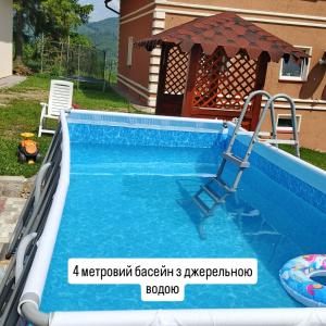 a swimming pool in a backyard with a swimming pooliterator at Під зорями in Slavske