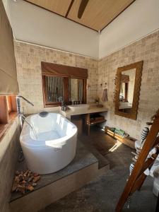 a large bathroom with a tub and a sink at Kampung Kecil Beach Front Boutique Hotel in Kubu