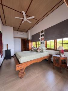 a bedroom with a large bed and a ceiling fan at Kampung Kecil Beach Front Boutique Hotel in Kubu