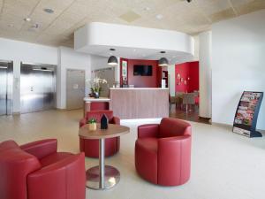 eine Lobby mit roten Stühlen, einem Tisch und einer Theke in der Unterkunft Campanile Ales Centre - Cévennes in Alès