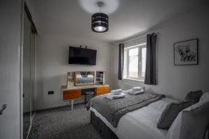 a bedroom with a bed and a desk and a window at Comfortable Home Near Supermarket with Parking & Garden in Bullingham