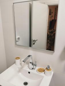 Un baño con un lavabo blanco y un espejo. en Dekel Dom Baharava, en Beʼer Ora