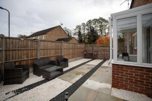 a patio with a wooden fence and a window at Comfortable Home Near Supermarket with Parking & Garden in Bullingham