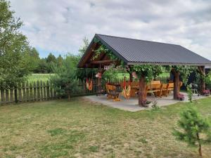 Dubicze CerkiewneにあるGospodarstwo Agroturystyczne ŻARNOWIECの庭のテーブルとベンチ付きパビリオン