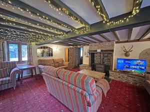 een woonkamer met twee banken en een open haard bij Duvale Barn in Bampton