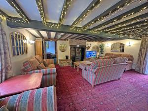 een grote woonkamer met banken en een televisie bij Duvale Barn in Bampton