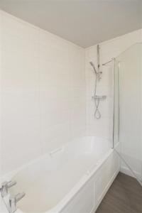 a white bathroom with a shower and a tub at Millers Cottage in Woodbridge