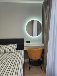 a bedroom with a bed with a mirror and a chair at ZEN home in Chişinău