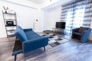un salon avec une chaise bleue et une télévision dans l'établissement City Center Accommodation - 505, à Reşiţa