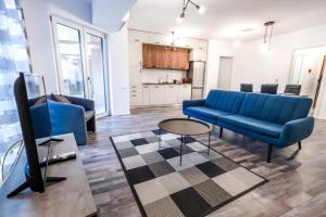 un salon avec un canapé bleu et une télévision dans l'établissement City Center Accommodation - 505, à Reşiţa