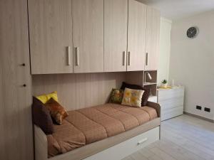 a bed in a room with wooden cabinets at La Casa Del Borgo in Torre Pellice