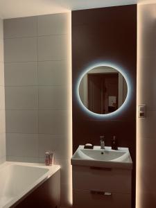 a bathroom with a sink and a mirror at Apartament 30 City Park nad jeziorem in Szczecinek +8 photos
