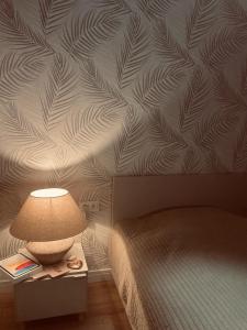 a bedroom with a bed and a lamp on a night stand at Apartament 30 City Park nad jeziorem in Szczecinek