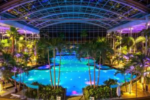 een groot zwembad in het attractiepark 's nachts bij WRW Airport Residence in Otopeni