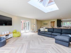 Great BirchamにあるCherry Ridgeのリビングルーム(青いソファ、天窓付)