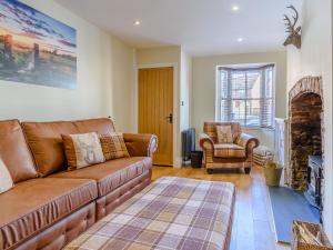 ein Wohnzimmer mit einer Couch und einem Sessel in der Unterkunft Hidden Winds Cottage in Guisborough