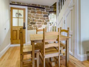 ein Esszimmer mit einem Holztisch und Stühlen in der Unterkunft Hidden Winds Cottage in Guisborough + 15 Fotos