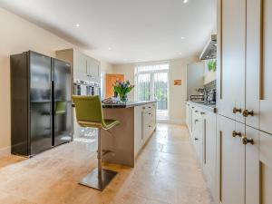 a large kitchen with a green chair in the middle at Old Barn 1 - Uk48477 in Ferndown