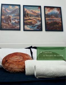 a room with a bed with four pictures on the wall at Casa Studio térreo com vaga de garagem in Curitiba