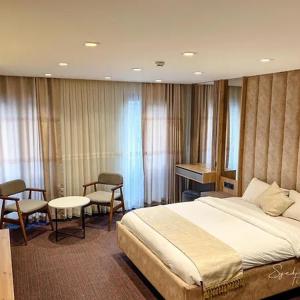 ein Schlafzimmer mit einem Bett und einem Tisch und Stühlen in der Unterkunft Batın Hotel in Istanbul