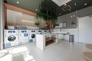 a laundry room with three washing machines and a counter at Studio Elegante Próxi a USP By Marcolini in Sao Paulo