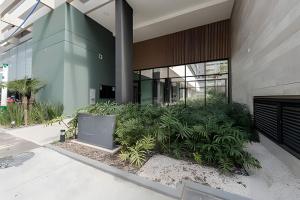 a building with a bunch of plants in front of it at Studio Elegante Próxi a USP By Marcolini in Sao Paulo