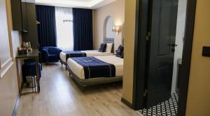 ein Hotelzimmer mit zwei Betten und einem Badezimmer in der Unterkunft Batın Hotel in Istanbul + 4 Fotos