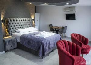 ein Schlafzimmer mit einem Bett und zwei roten Stühlen in der Unterkunft Batın Hotel in Istanbul