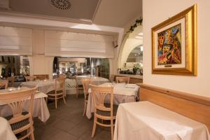 a restaurant with tables and chairs and a picture on the wall at Hotel Bernina in Tirano