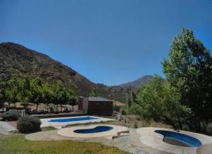 two swimming pools in a yard with mountains in the background at Entre Montañas - Vista Calma in Potrerillos