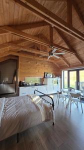 a bedroom with a bed and a kitchen and a ceiling at Lodge Klein Ganseij in Olst
