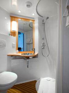 a bathroom with a shower and a toilet and a sink at Martini Hotel in Groningen