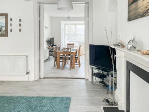 a living room with a television and a dining room at Seaglass in Marazion