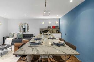 a kitchen and living room with a table and chairs at Contemporary 2-Bedroom Escape in Notting Hill in London