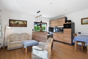 a living room with a couch and a kitchen at Haus am See - Wohnung Königssee in Königssee
