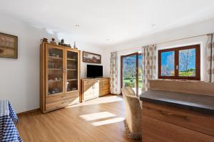 a room with a bedroom with a tv and a window at Haus am See - Wohnung Königssee in Königssee