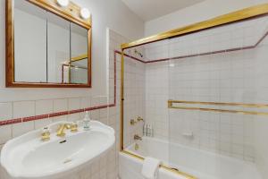 a bathroom with a sink and a tub and a mirror at West End Wanderlust in Eureka +11 photos