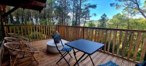 a porch with chairs and a table on a deck at Le Masdemoiselle Chalet in Salernes