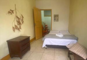 a bedroom with a bed and a table and a door at kitnet no Centro histórico in São João del Rei +4 photos