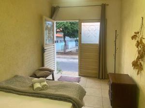 a bedroom with a bed and a sliding glass door at kitnet no Centro histórico in São João del Rei