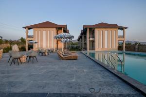 um resort com piscina, cadeiras e guarda-sóis em The Bhagwati Cottage & Villa em Ābu Road mais 118 fotografias