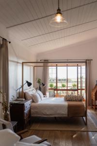 une chambre avec un grand lit avec une grande fenêtre dans l'établissement Olyf guestcottage, à Bloemfontein