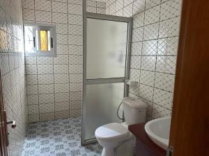 a bathroom with a toilet and a sink at LesOiseaux in Yaoundé +11 photos