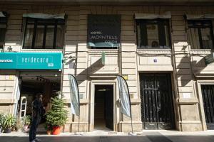 a man is standing in front of a building at Moontels Colón in Valencia